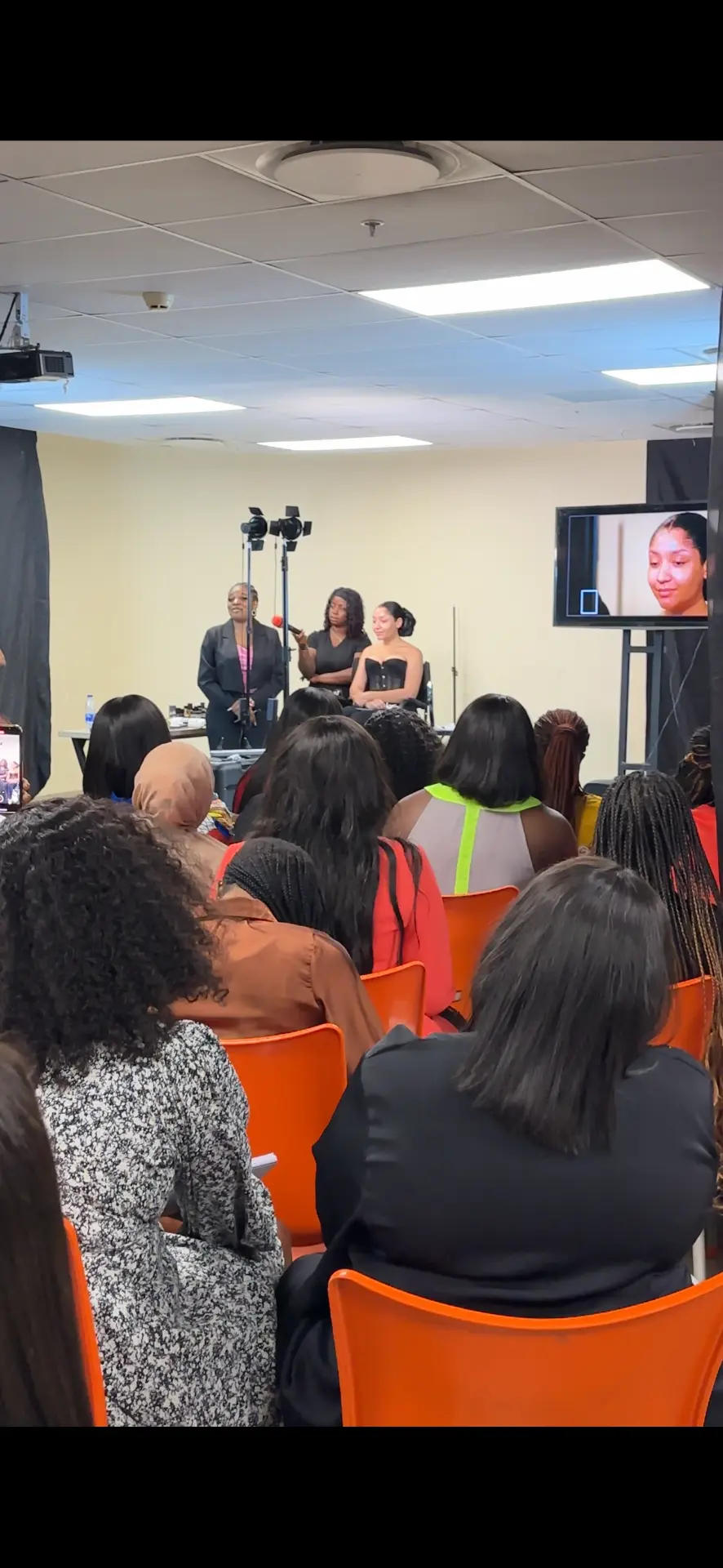 Students watching a live makeup demonstration in class